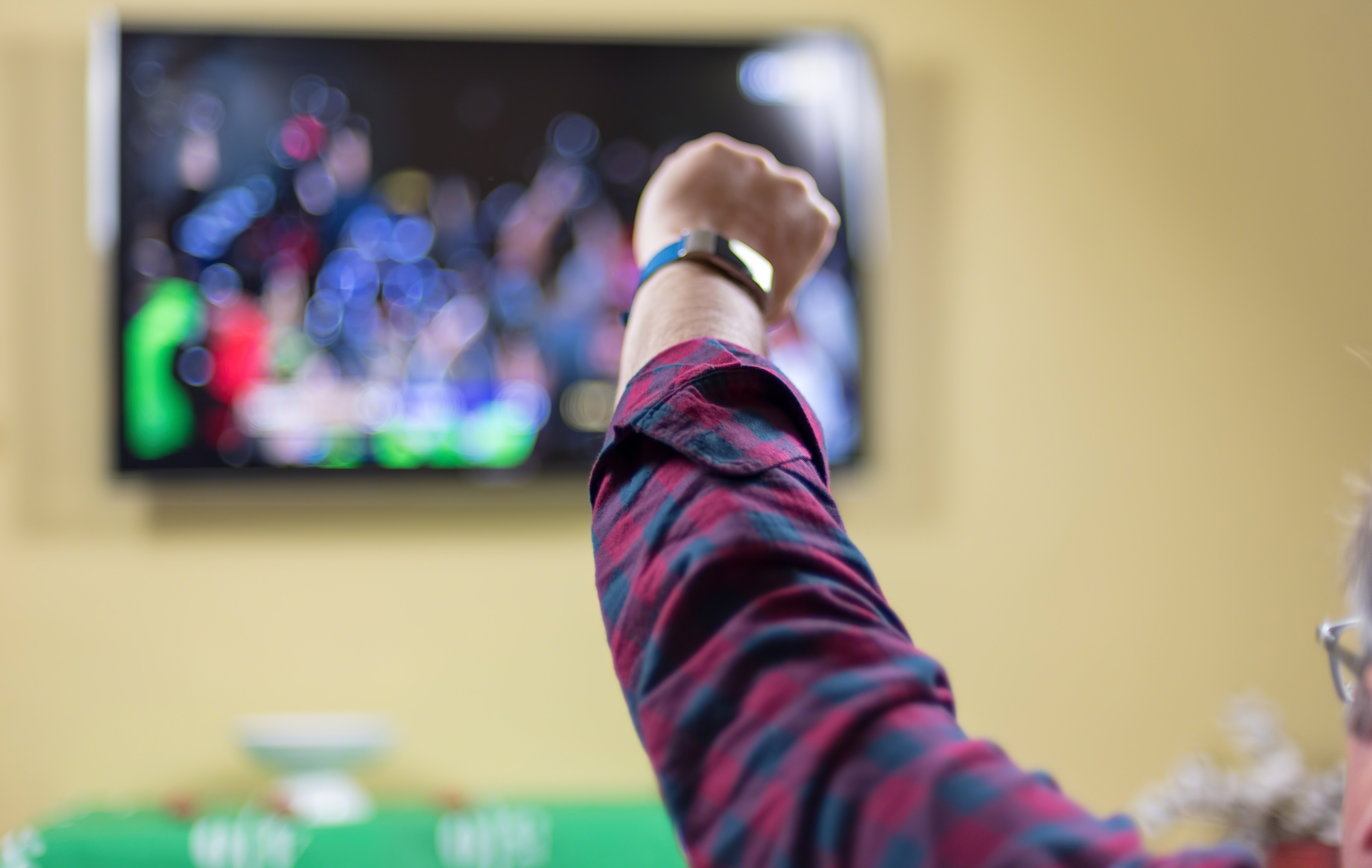 man-watching-sports-on-tv-cheering-for-team-2021-08-30-11-13-10-utc